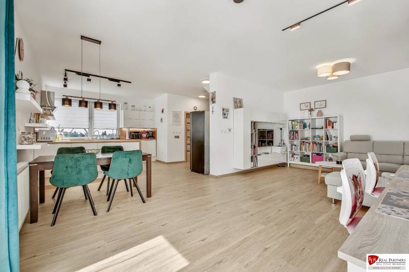 The interior of the family house offers a kitchen with a dining area, a bright living room, and a library.
