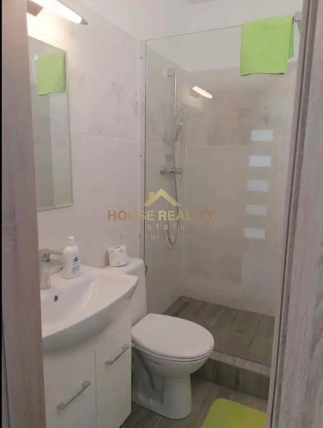 Bathroom with a shower and toilet in the amenities of a studio apartment.