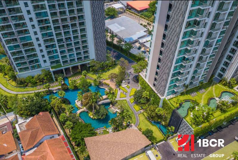 Construction of apartments in the city of Pattaya, with landscaped gardens and swimming pools near residential buildings.