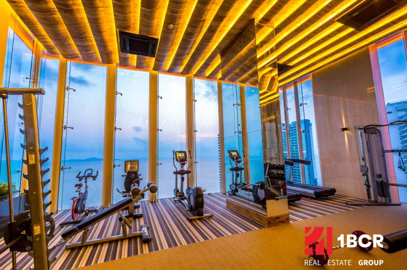 Fitness center with a sea view and modern equipment within the apartment development.