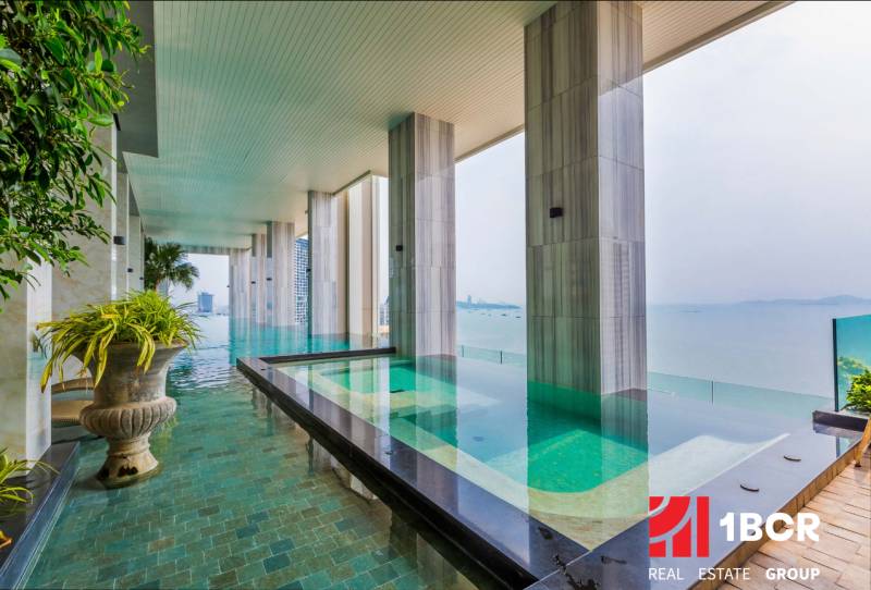 A swimming pool with a stunning sea view within the construction of apartments in Pattaya.