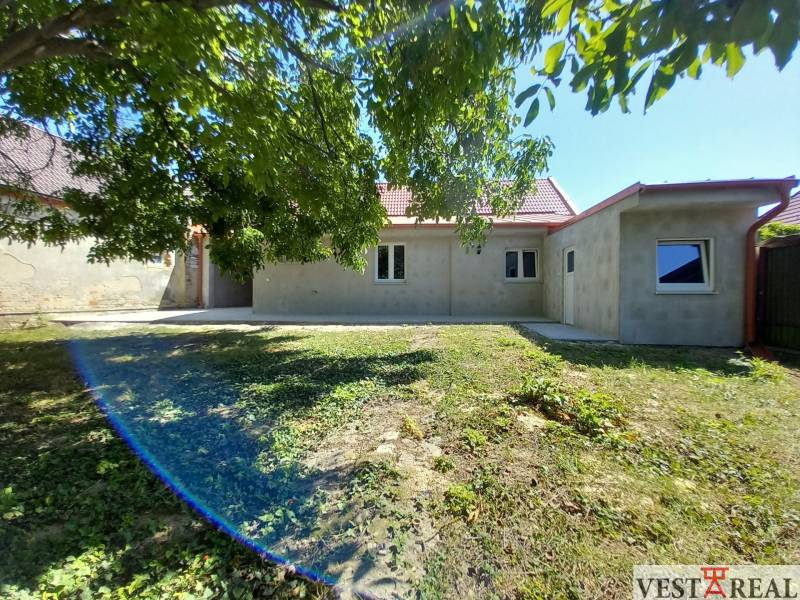 A family house in Trakovice with a garden, surrounded by trees and green grass.