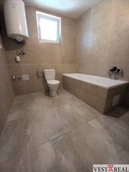 Bathroom in a family house with a bathtub, toilet, and boiler.