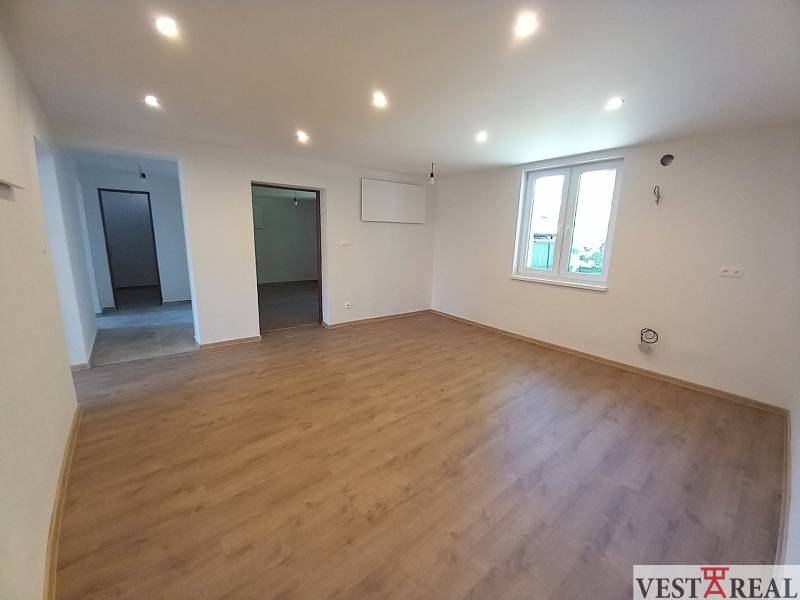 Living room in a family house with wooden flooring and white walls.