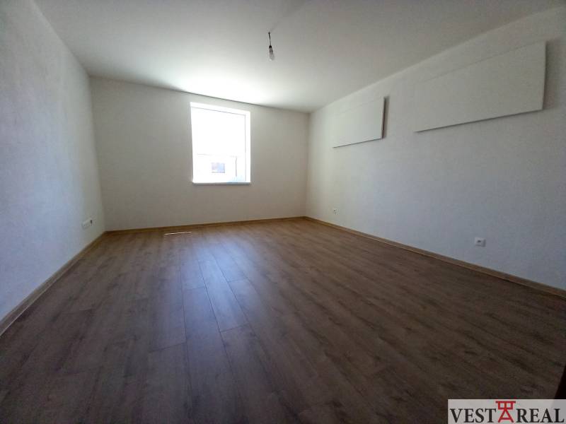 A room with a wooden floor and a bright window in a family house.