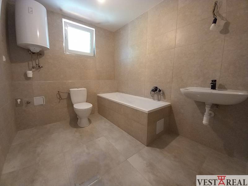 Bathroom in a family house with a bathtub, sink, and toilet.
