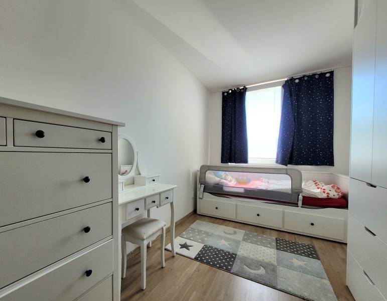 Children's room with a bed, dresser, and carpet in a 3-room apartment.