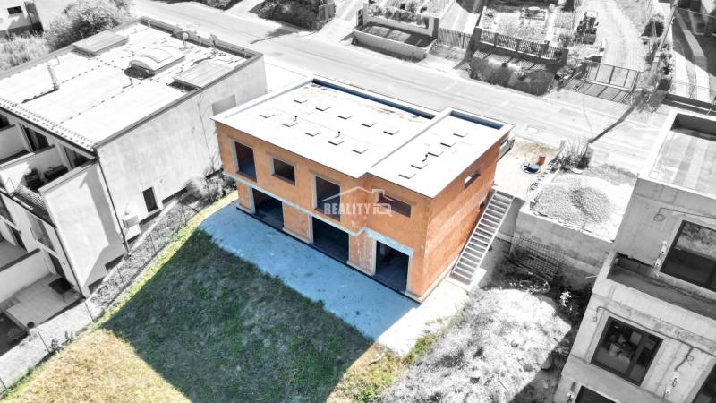 An unfinished family house in Trnové, Žilina, surrounded by a green plot and neighboring houses.