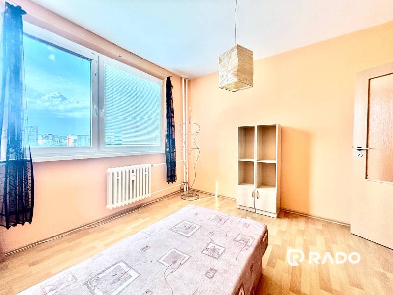 A bright room with a bed and a cabinet in a 3-room apartment.