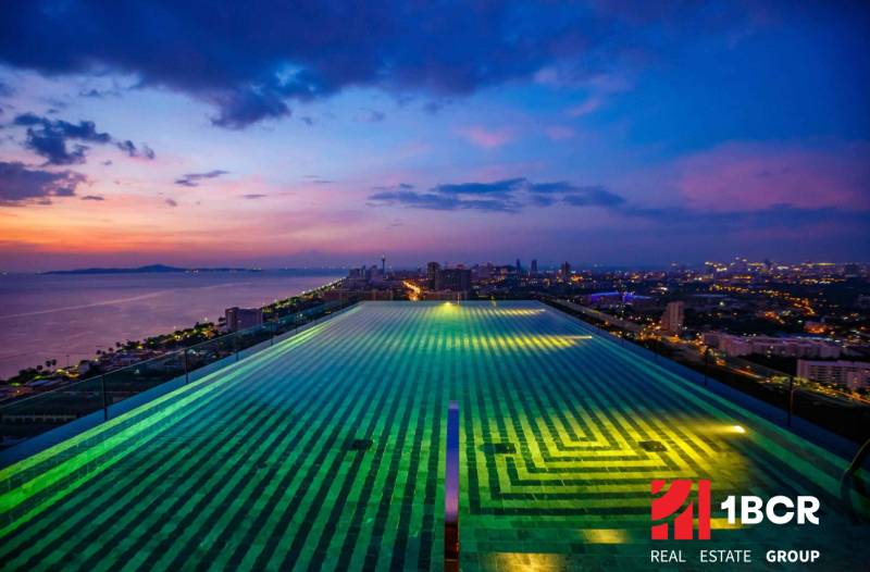 A view of the rooftop pool overlooking the evening skyline of Pattaya.