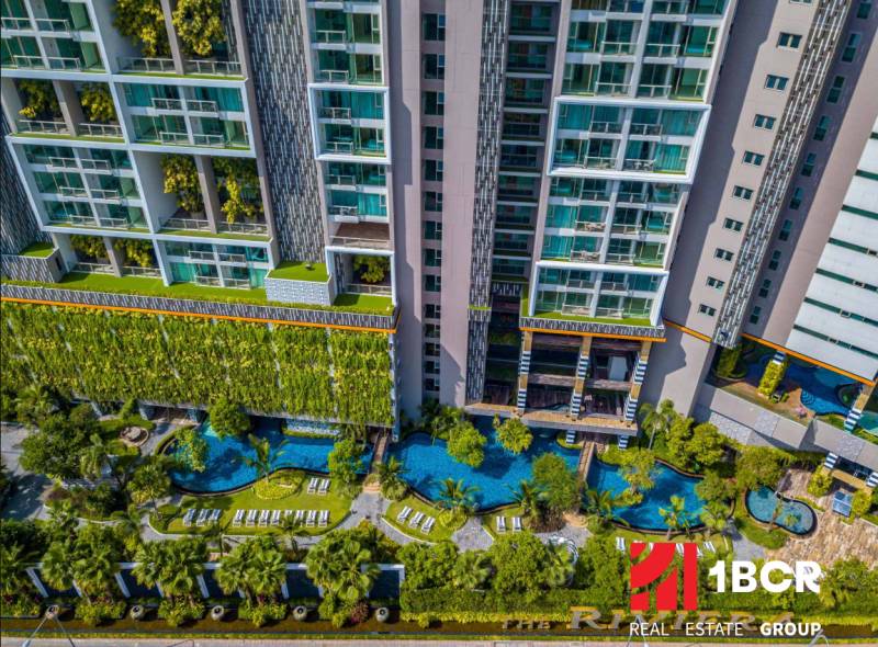 Apartment construction in Pattaya with panoramic views of pools and greenery.