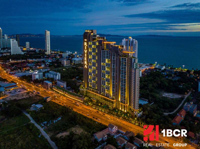 Construction of apartments in the city of Pattaya by the sea, illuminated skyscrapers and city skyline.
