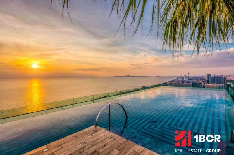 Apartment construction in Pattaya at sunset with a view of the infinity pool.