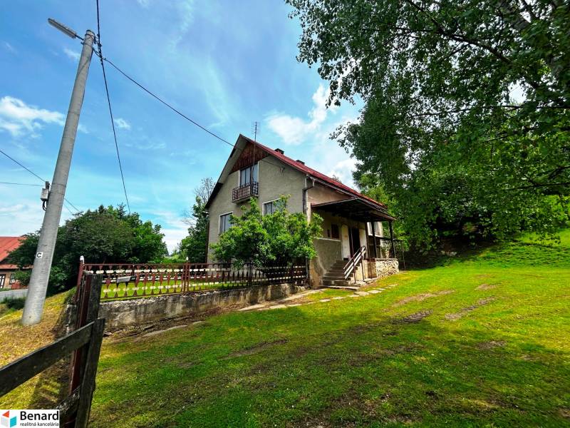 A family house in Veľká Lesná with an extensive yard and tree vegetation.