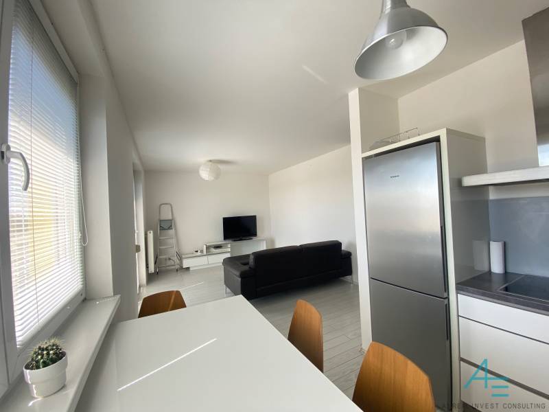 A bright kitchen in a 3-room apartment with a dining table and modern appliances.