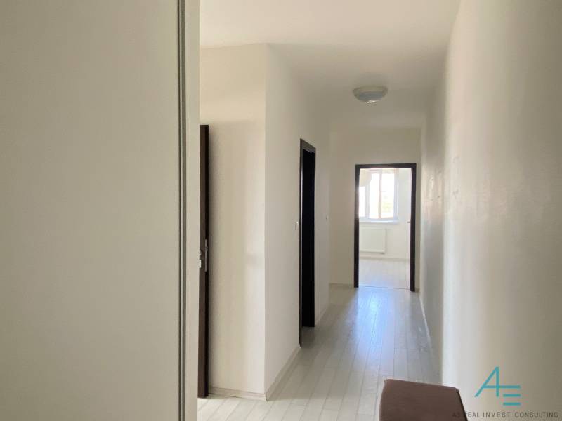 A hallway in a 3-room apartment with white walls, doors leading to rooms.