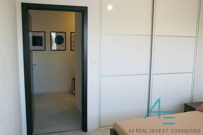 Interior of a 3-room apartment with a white built-in wardrobe and wall decorations.