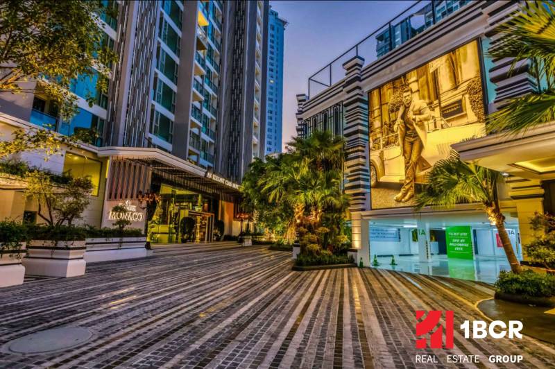 Night architecture during apartment construction in Pattaya with illuminated street and vegetation.