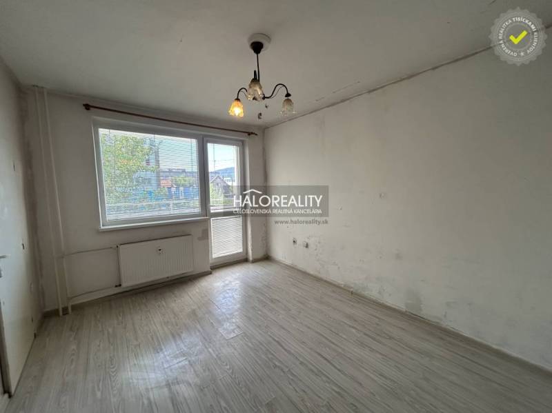 A spacious room with laminate flooring and large windows in a studio apartment.