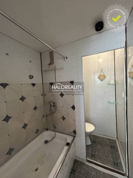 Bathroom with a bathtub and shower head in a studio apartment, simple design.