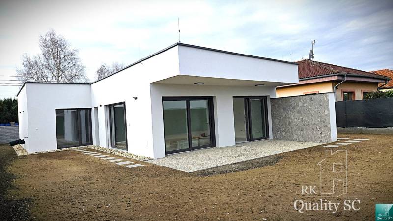 A family house in Turany with a flat roof and large glass doors.