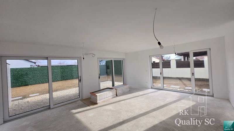 A family house interior full of light with large windows and a view of the garden.