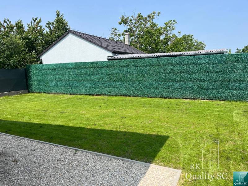 The garden of a family house in Tureň with a well-maintained lawn and a screen.