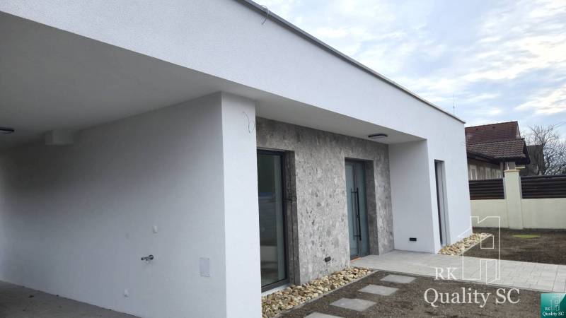 A family house in Tureň with a light facade and stone cladding at the entrance.