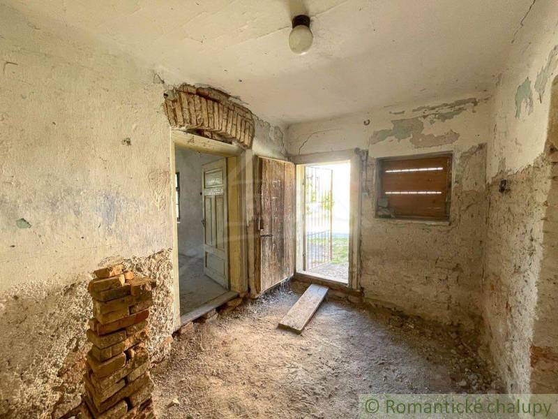 An abandoned room with peeling plaster in a family house, capturing a rustic atmosphere.