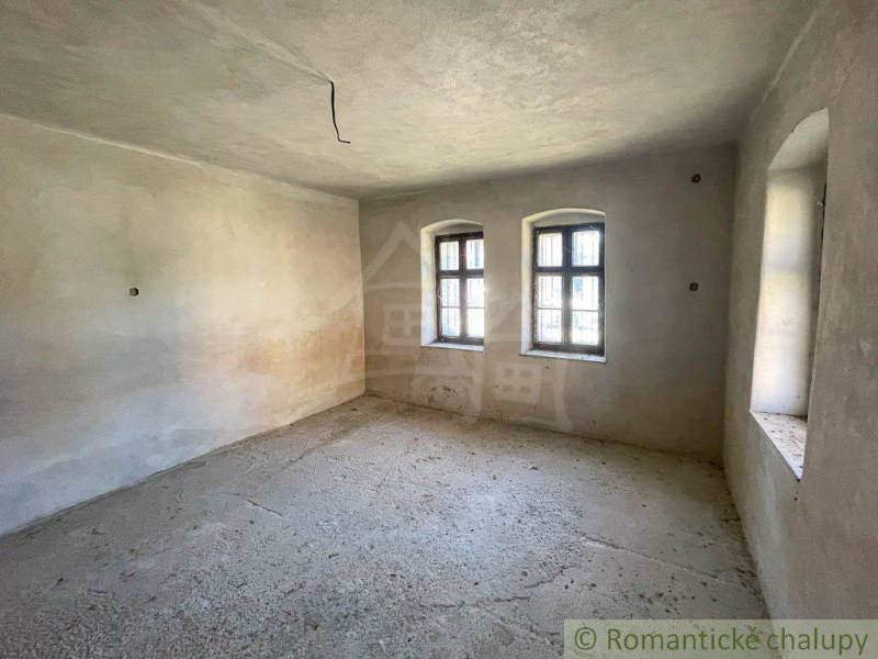 An empty room with two windows in a family house.