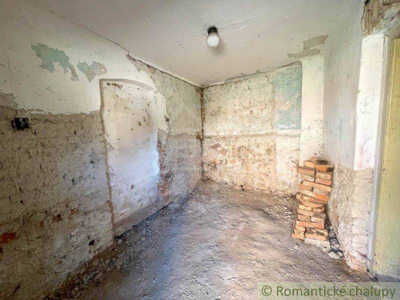 An abandoned room with unfinished walls and a pile of bricks in a family house.
