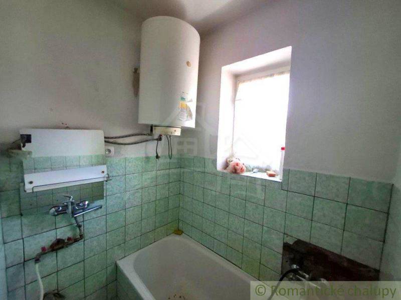 A bathroom in a family house with a gas boiler and tiles.