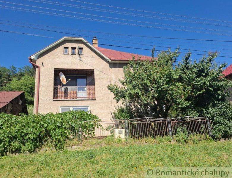 Family house in Lovinobaňa, brick facade, satellite dish, garden, and fence.