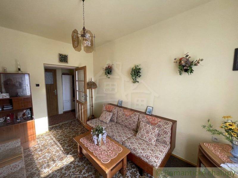 Living room in a family house with retro furniture, decorations, and floral patterns.