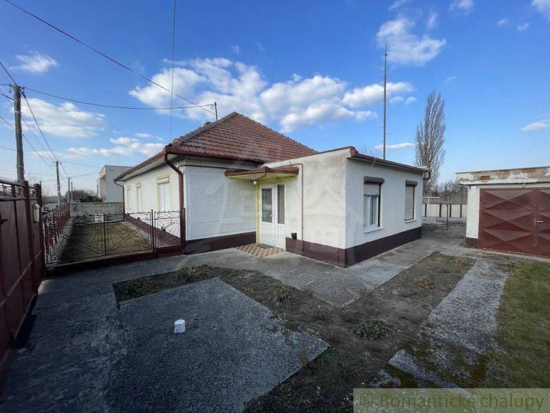 A family house in Nové Zámky with a small courtyard, a garage, and a metal fence.