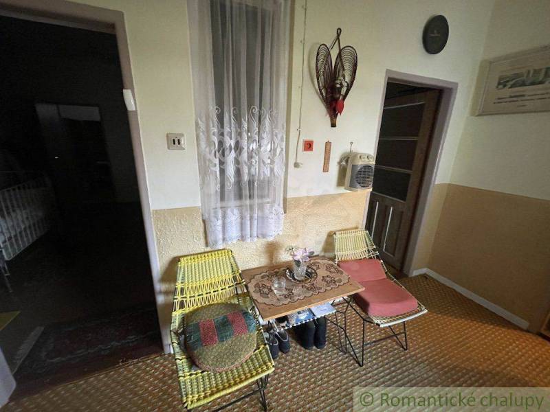 Two woven chairs and a table with flowers in a family house, interior.