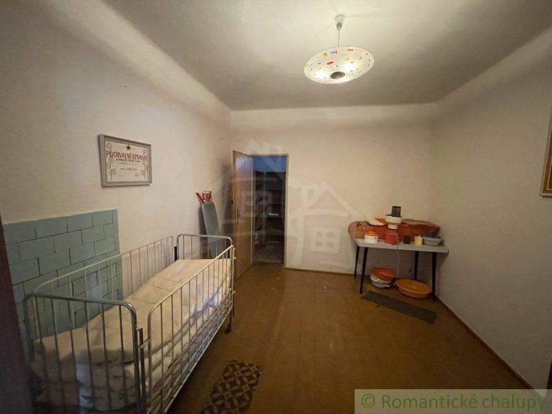 Interior of a family house with a crib, seating, and a nostalgic atmosphere.