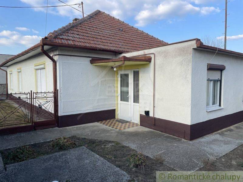 A family house in Nové Zámky with a white facade and a pitched roof.