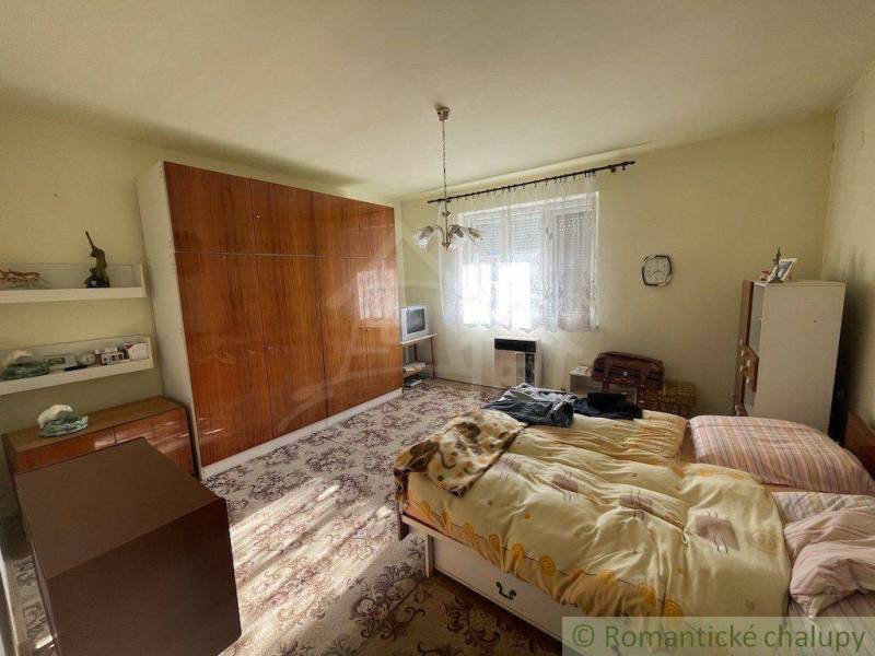 A bedroom in a family house with antique furniture, a bed, and a television.