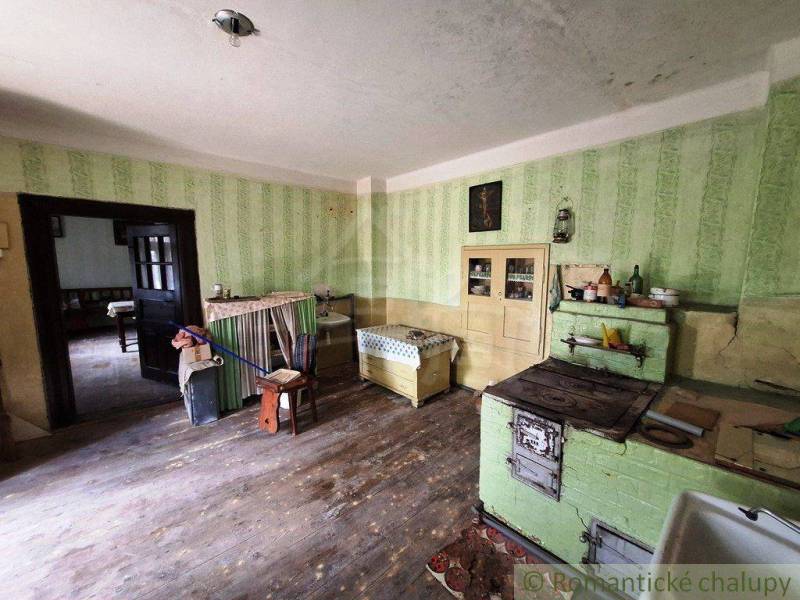 A kitchen in a family house with antique furniture and a stove, visible wooden floor.