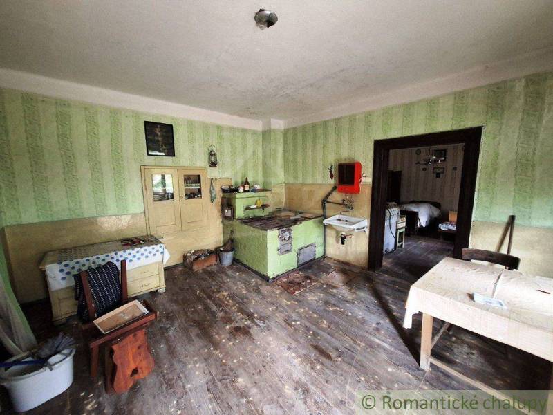 A traditional kitchen of a family house with a tiled stove and period furniture.