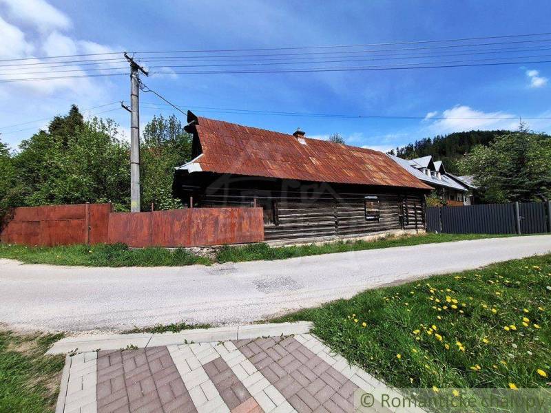 A family house in Pohorelá with a wooden structure, next to the road and greenery.