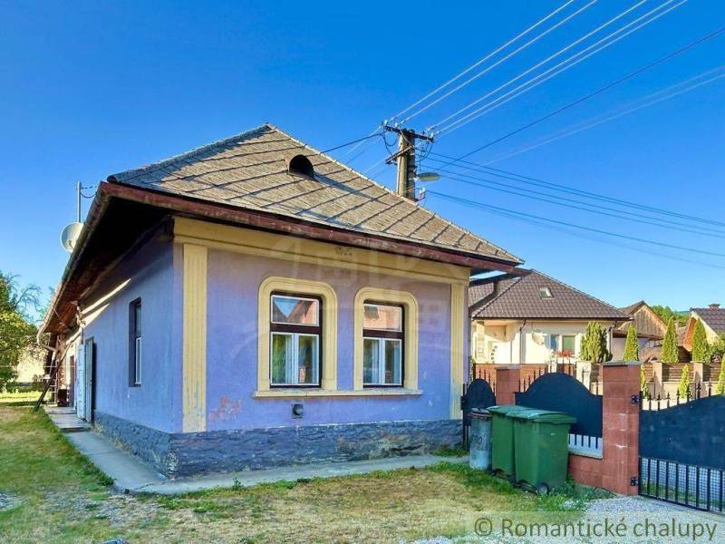 A family house in Gemerská Poloma with a blue facade and windows framed in yellow.