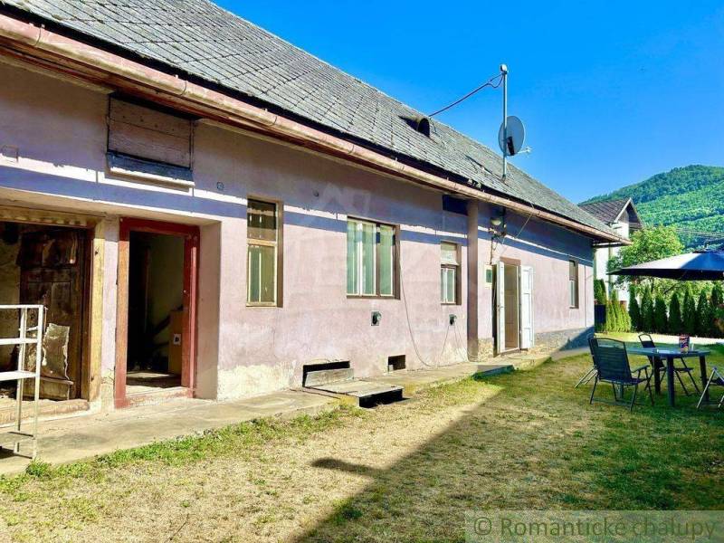 A family house in Gemerská Poloma with a yard, chairs, and a view of the surrounding nature.