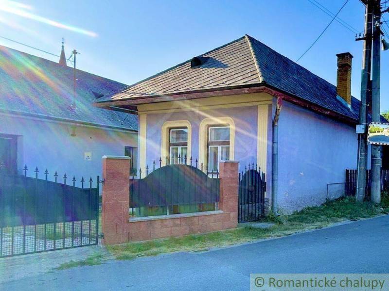 A family house in Gemerská Poloma with a colorful facade, a strong fence, and windows with bars.