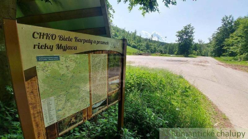 Information board in the White Carpathians near Stará Myjava surrounded by greenery with a road.