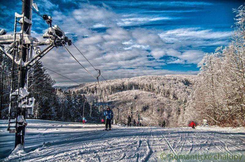 Snow-covered slopes and a ski lift in winter surrounded by forests in Stará Myjava.