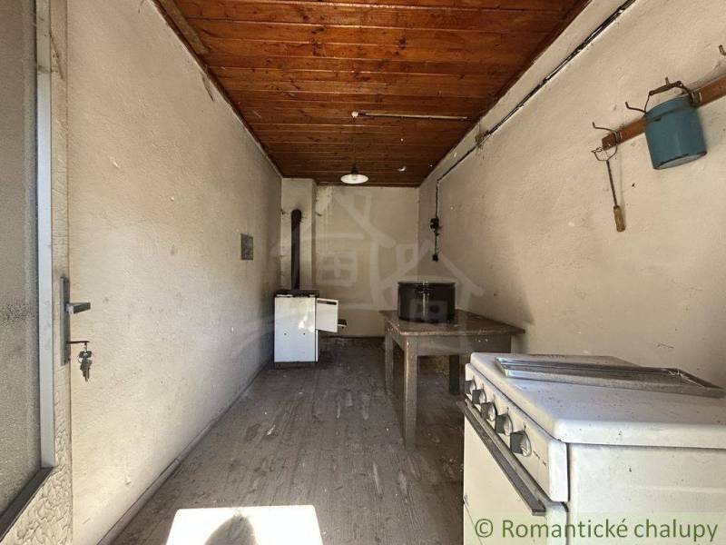 A kitchen in a family house with a wooden beam ceiling and a wall hanger.