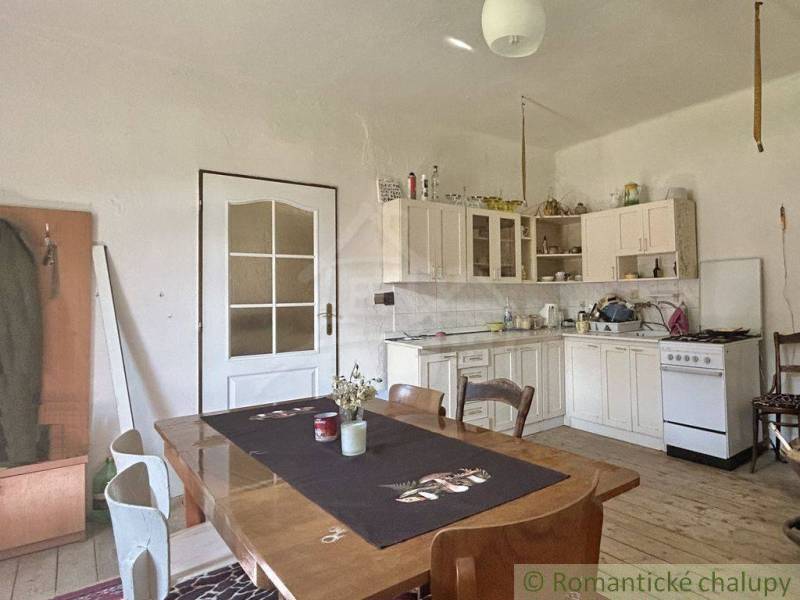 A kitchen in a family house with a wooden table and white furniture.