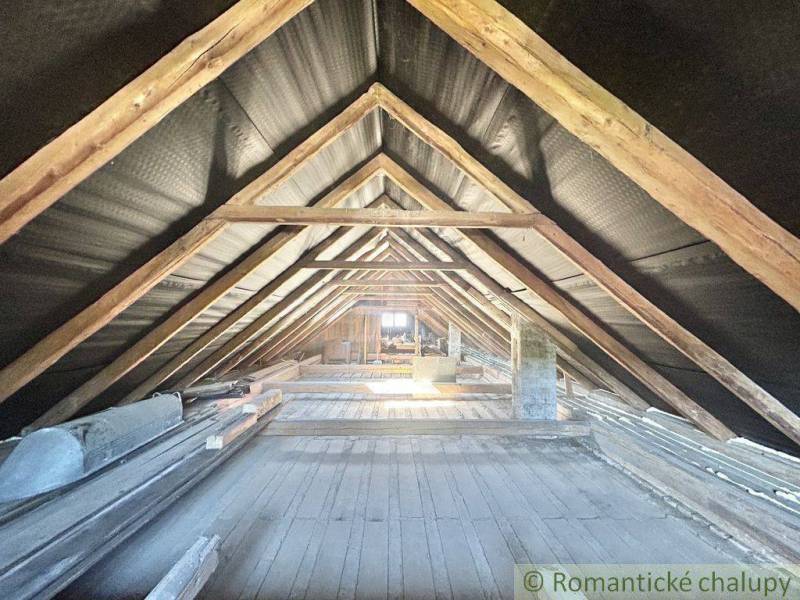 Attic in a family house with wooden beams without attic conversion.